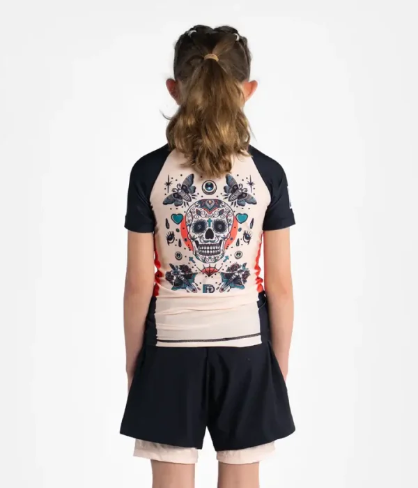 Little boy wearing a Progress Kids Sugar Skull Rash Guard