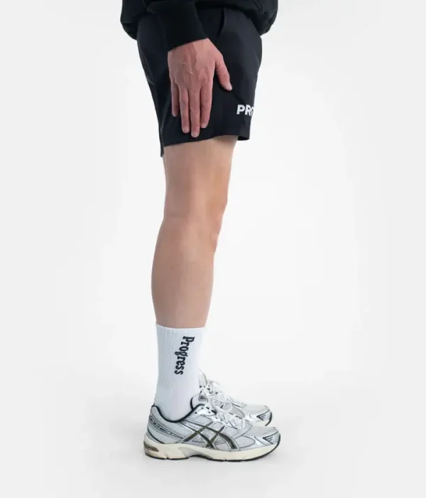 Two white and black Progress PRO socks on a neutral background
