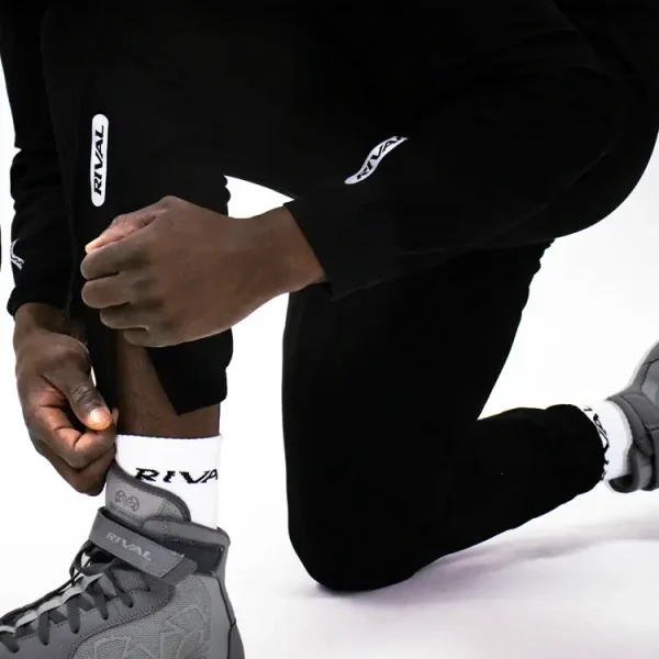 Black rival track pants with white stripes on model