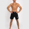 Man wearing Venum Contender fight shorts in a fighting stance