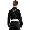 Kid wearing a Venum Contender Kids BJJ Gi with free white belt