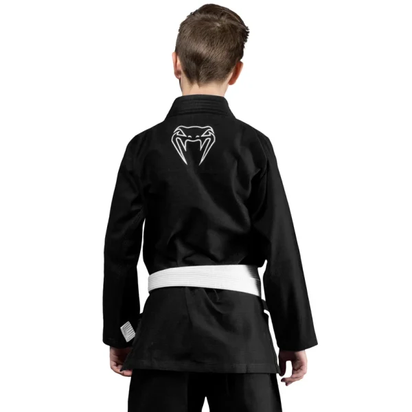 Kid wearing a Venum Contender Kids BJJ Gi with free white belt