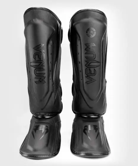 Venum Elite Evo Shin Guards laid out on a white background