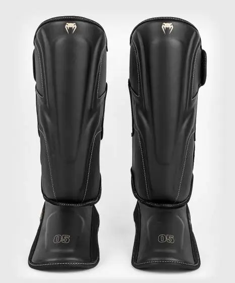 Venum Impact Evo Shinguards in black and red on white background