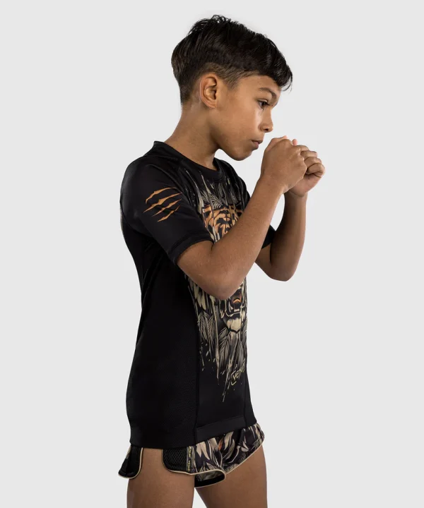 Venum Kids Tiger Short Sleeve Rash Guard Black Orange 1 Child posing in Venum Kids Tiger Short Sleeve Rash Guard