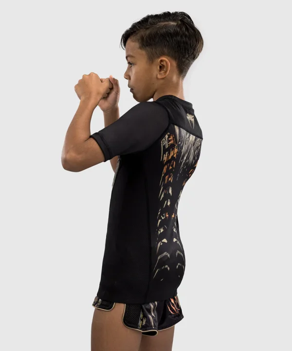 Venum Kids Tiger Short Sleeve Rash Guard Black Orange 2 Young child wearing Venum Kids Tiger Short Sleeve Rash Guard
