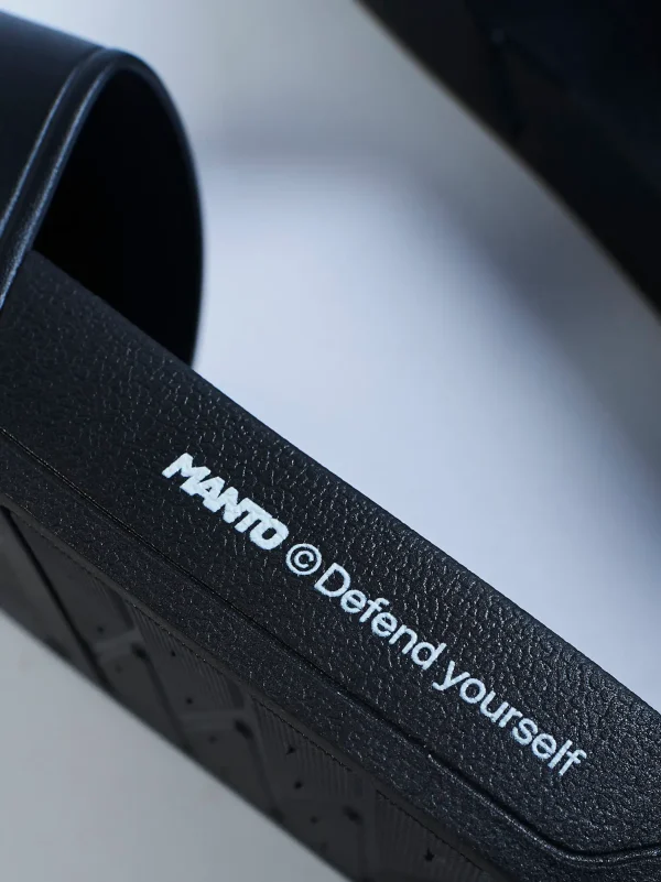 A pair of Manto Defend Slides on a plain background
