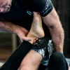 Athletic male wearing Tatami Fightwear Kanagawa Shorts for martial arts