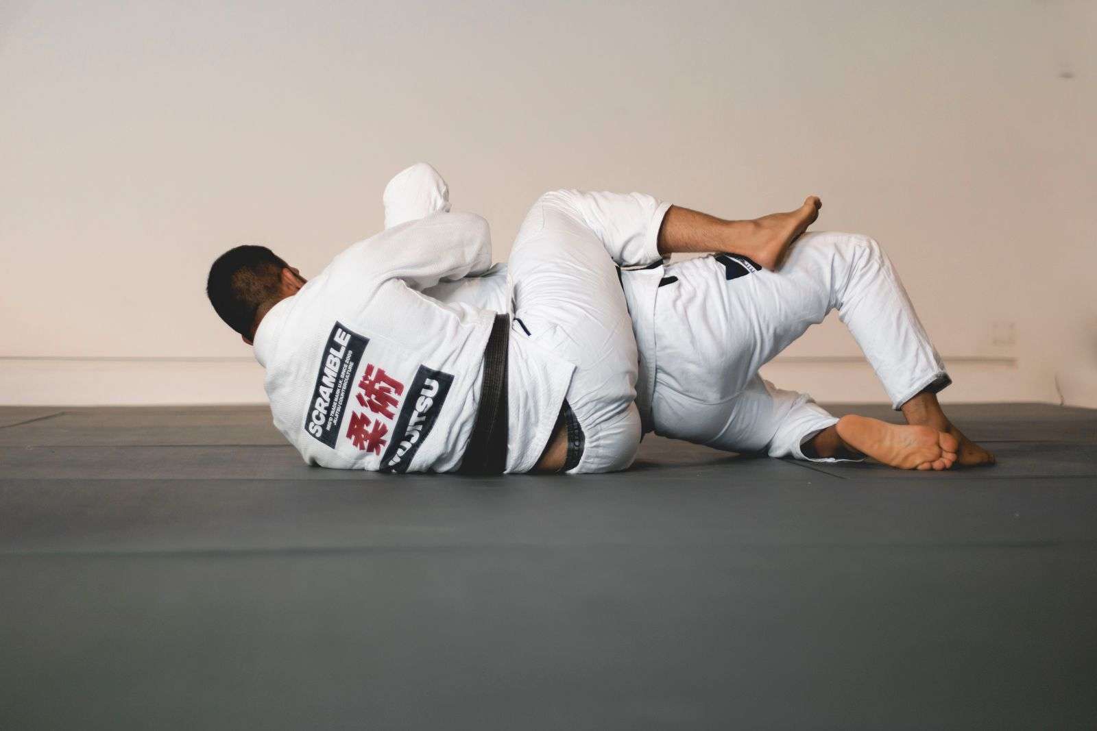 A fighter in a Scramble BJJ Gi locks in back control during jiujitsu sparring