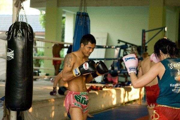 A man in Sandee Muay Thai shorts spars with a female partner