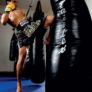 Muay Thai athlete kneeing the Fairtex HB7 Canvas and PU Punch Bags