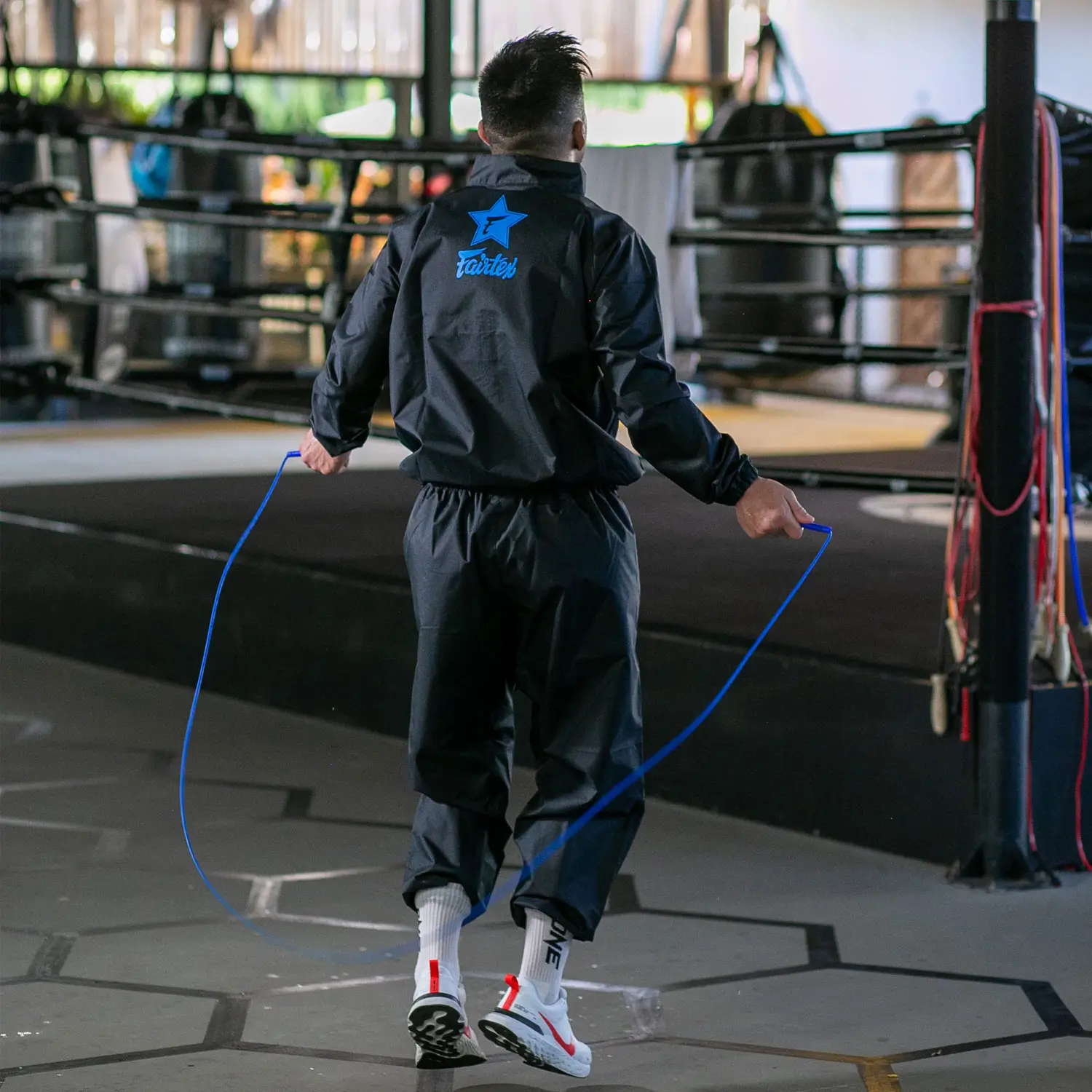 strength and conditioning title picture - A man skips with a skipping rope in a fairtex sweat suit