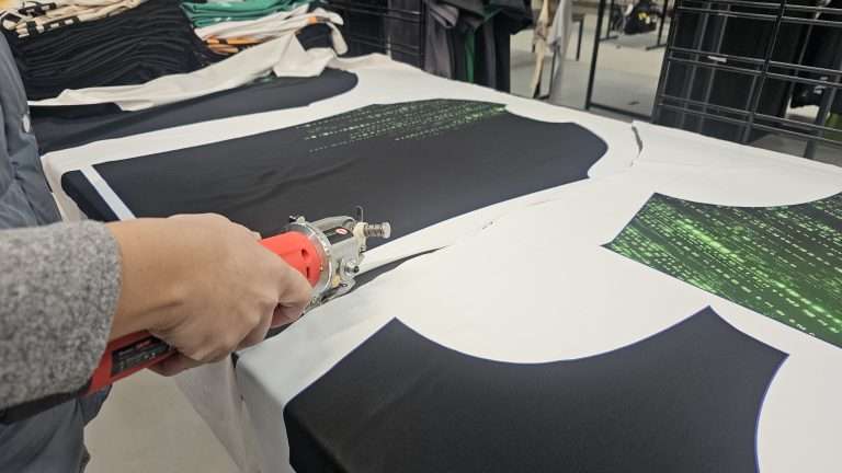 Printed fightwear fabric being hand cut during custom fightwear production at Brick & Grit UK
